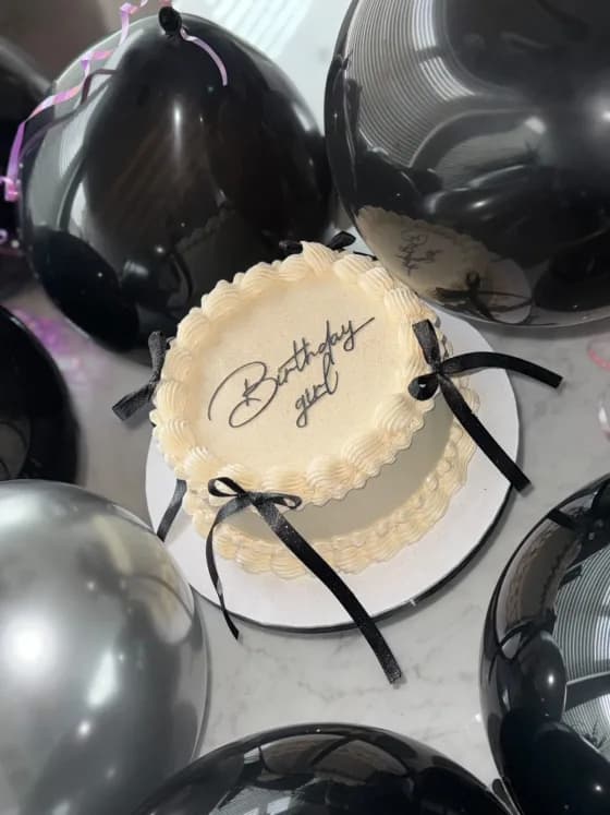 Tarta vintage redonda en crema con boquilla festoneada y lazos negros, LittleCakesNL Vlaardingen